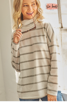 Striped Hacci top is features in a turtle neckline and long sleeves.